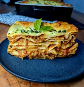 A slice of delicious lasagne, showing layers of pasta, ragu and cheese